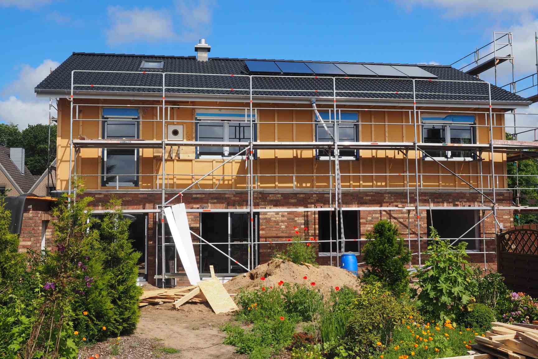 Neubau eines Wohnhauses mit Gerüst und Fassadendämmung vor der Fertigstellung