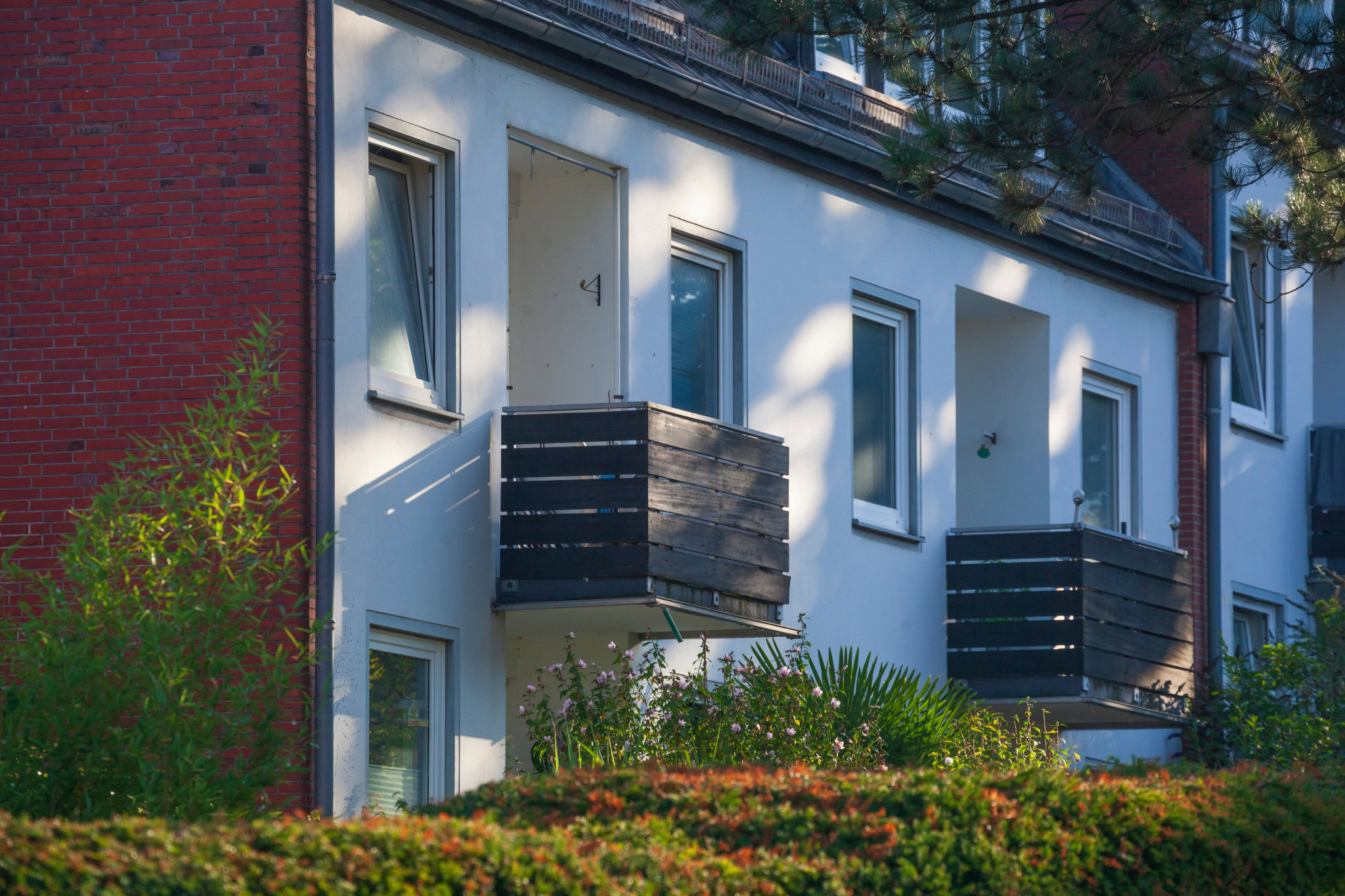 Mehrfamilienhaus mit Balkonen und gepflegtem Vorgarten in ruhiger Wohnlage.