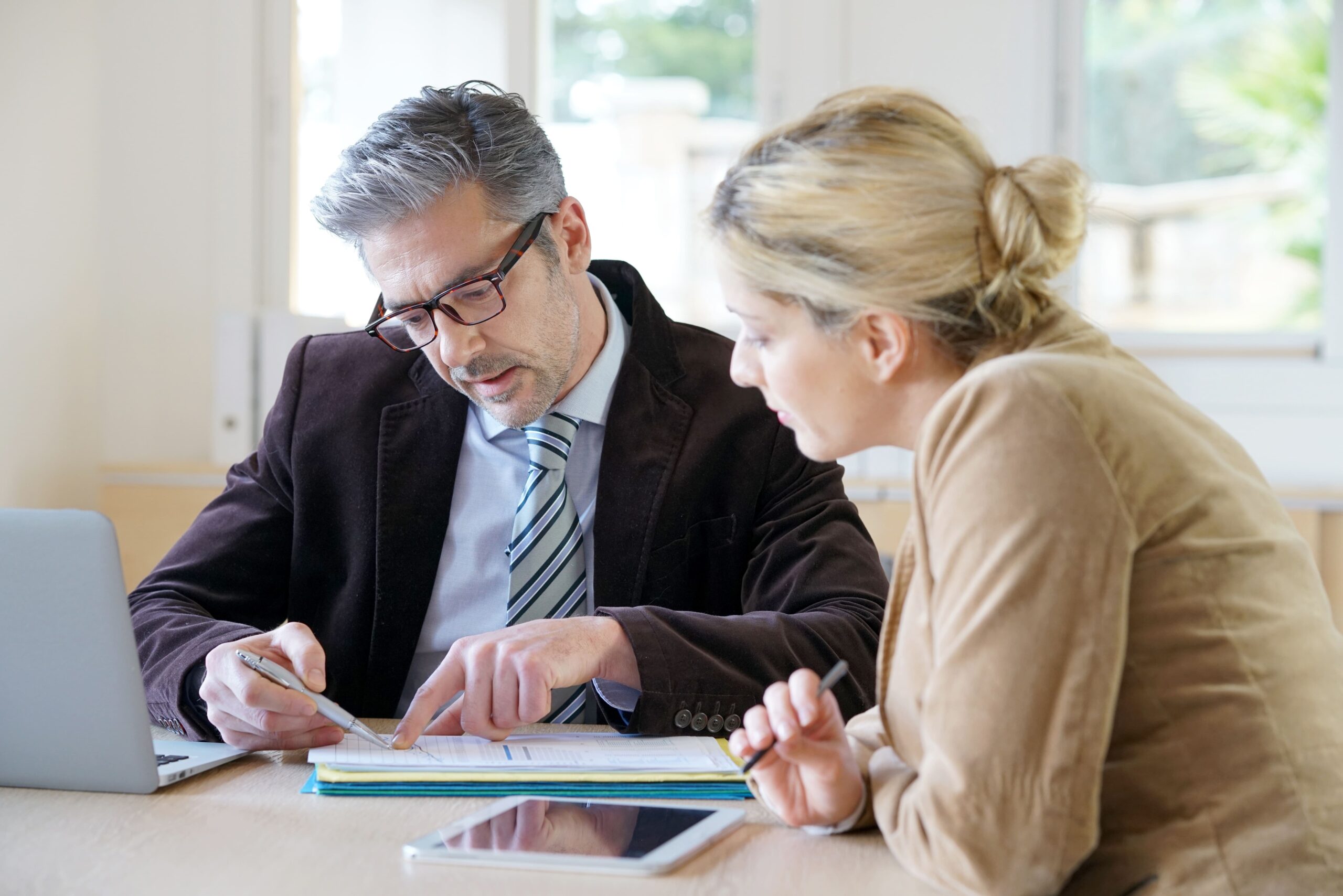 Zwei Personen studieren einen Auszug aus dem Grundbuch.