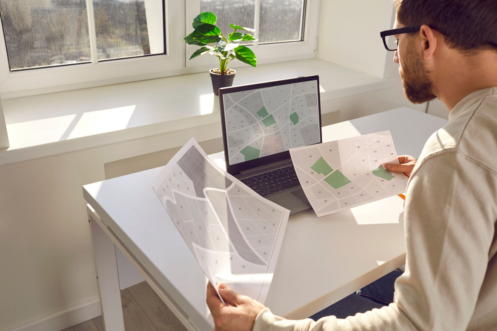 Ein Ingenieur, der am Schreibtisch sitzt und Baupläne anschaut