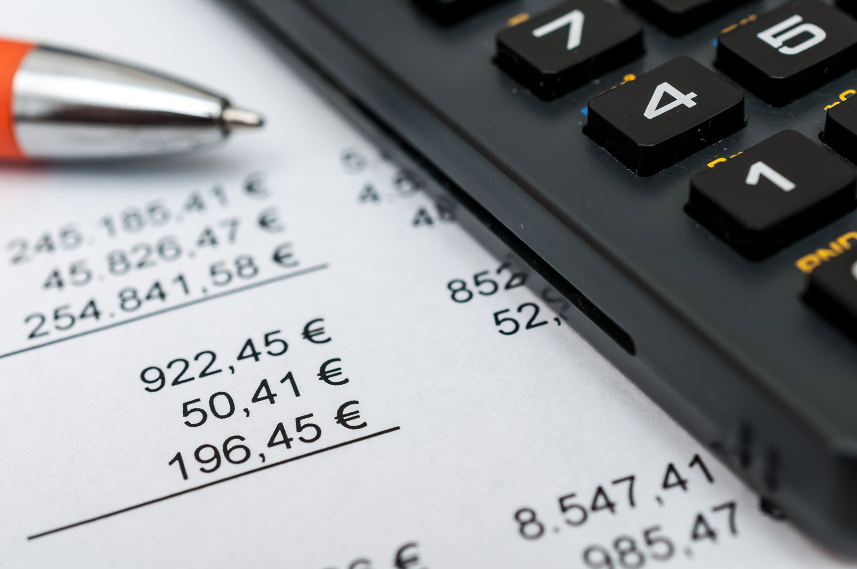 Dokument mit Berechnung der Nettoanfangsrendite. Daneben Taschenrechner und Kugelschreiber.